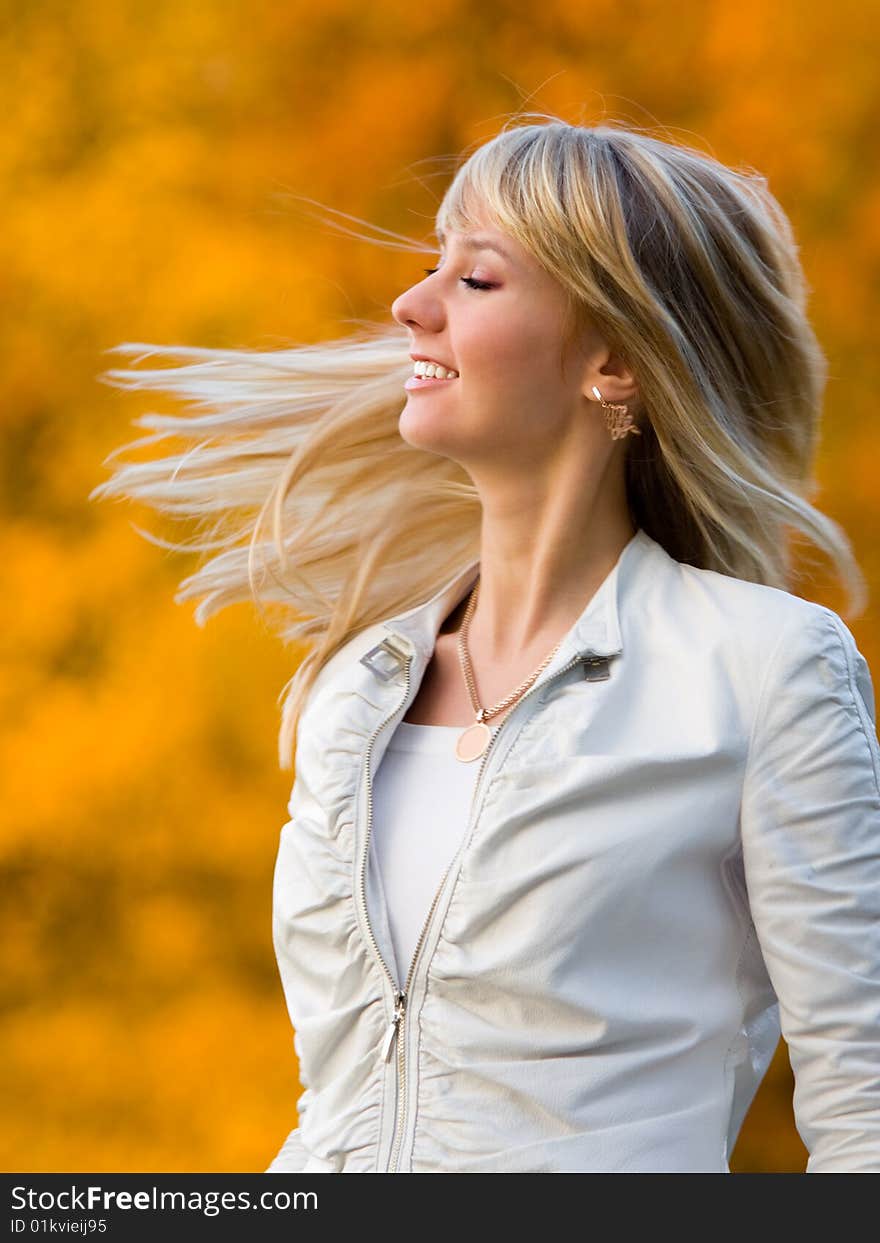 Pretty girl in white jacket on autumn park background - shallow DOF