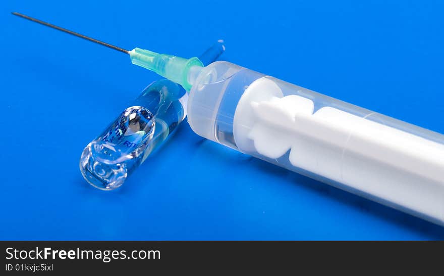 Syringe and ampoule on a dark blue background. Syringe and ampoule on a dark blue background.