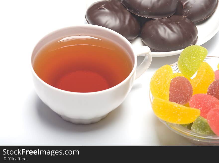 Cup with tea, a zephyr and fruit candy.