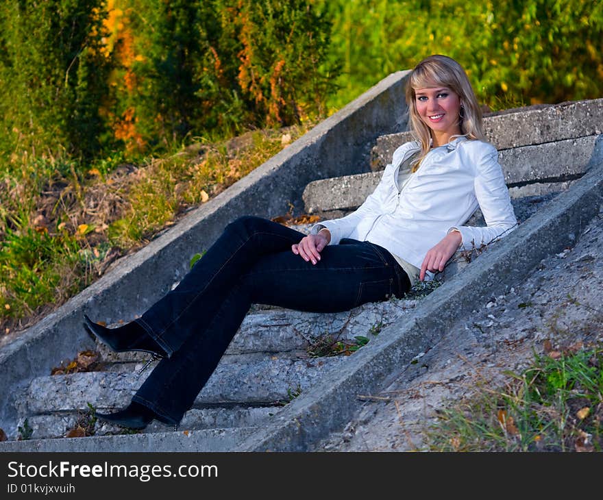 Pretty girl sitting on stone stair steps