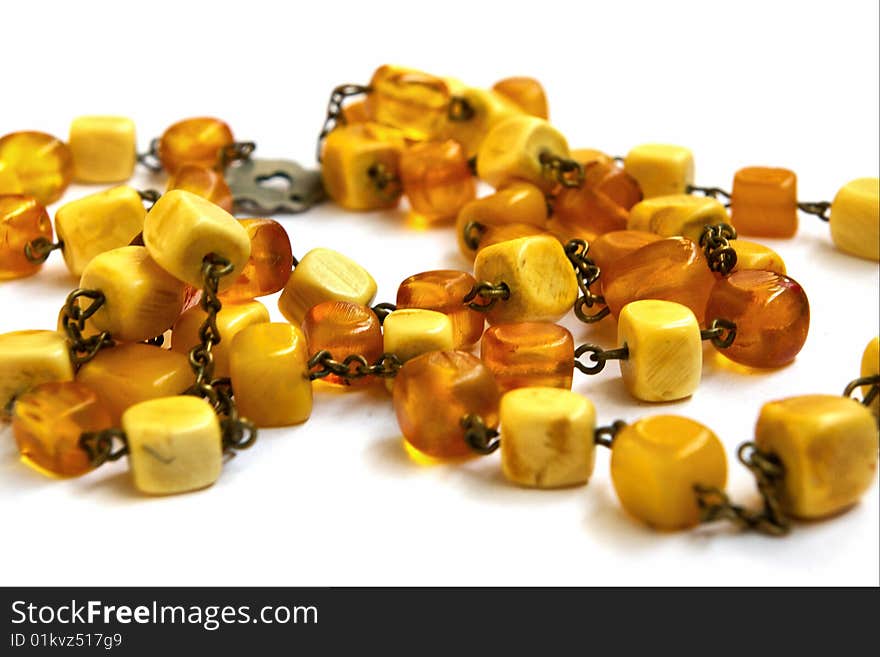 Necklace from natural amber with a fastener in the form of heart on a white background. Necklace from natural amber with a fastener in the form of heart on a white background