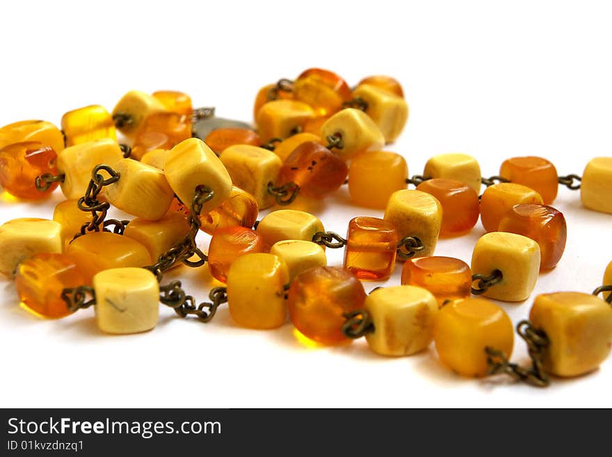 Necklace from natural amber with a fastener in the form of heart on a white background. Necklace from natural amber with a fastener in the form of heart on a white background