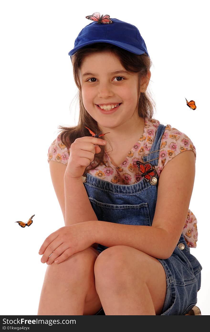 A portriat of a cute elementary girl with a monarch butterfly on her finger and others flying around or on her.  Isolated on white. A portriat of a cute elementary girl with a monarch butterfly on her finger and others flying around or on her.  Isolated on white.