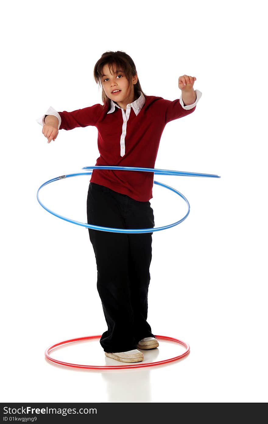 An older elementary girl successfully spinning two hoola hoops at a time.  Isolated on white. An older elementary girl successfully spinning two hoola hoops at a time.  Isolated on white.