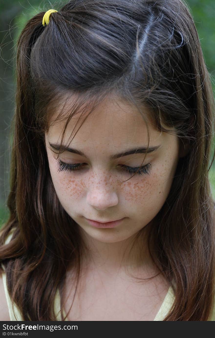 Beautiful brown hair girl looking thoughtful and peaceful outdoors at the park. Beautiful brown hair girl looking thoughtful and peaceful outdoors at the park.