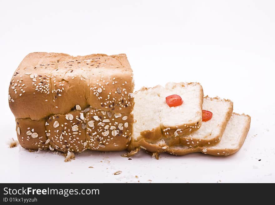 White background, bread in peieces, covered with til seed, cornmeal, tomato pieces on. White background, bread in peieces, covered with til seed, cornmeal, tomato pieces on