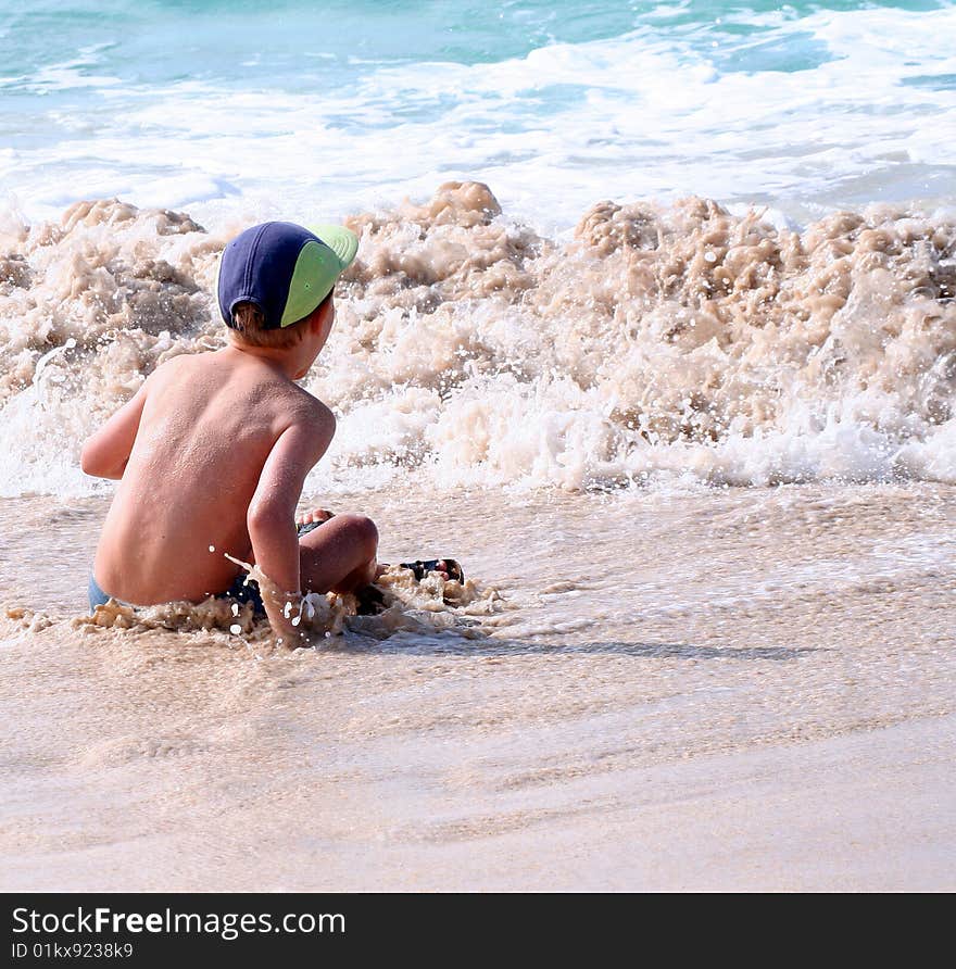 A young boy is playing on the beach