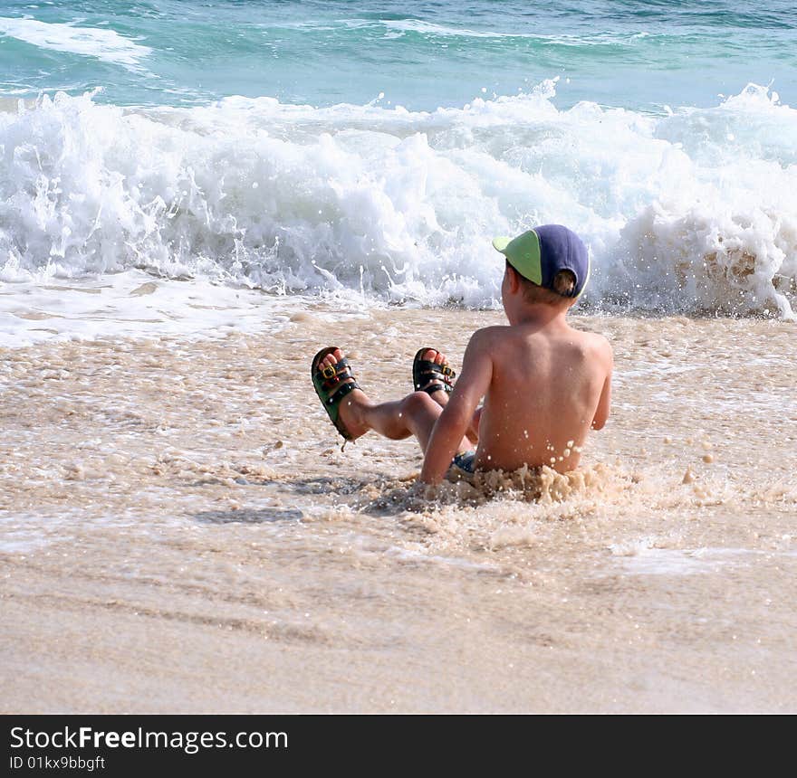 A young boy is playing on the beach