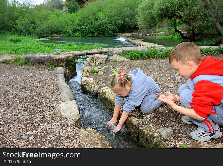 Little boy and girl playing with water. Little boy and girl playing with water