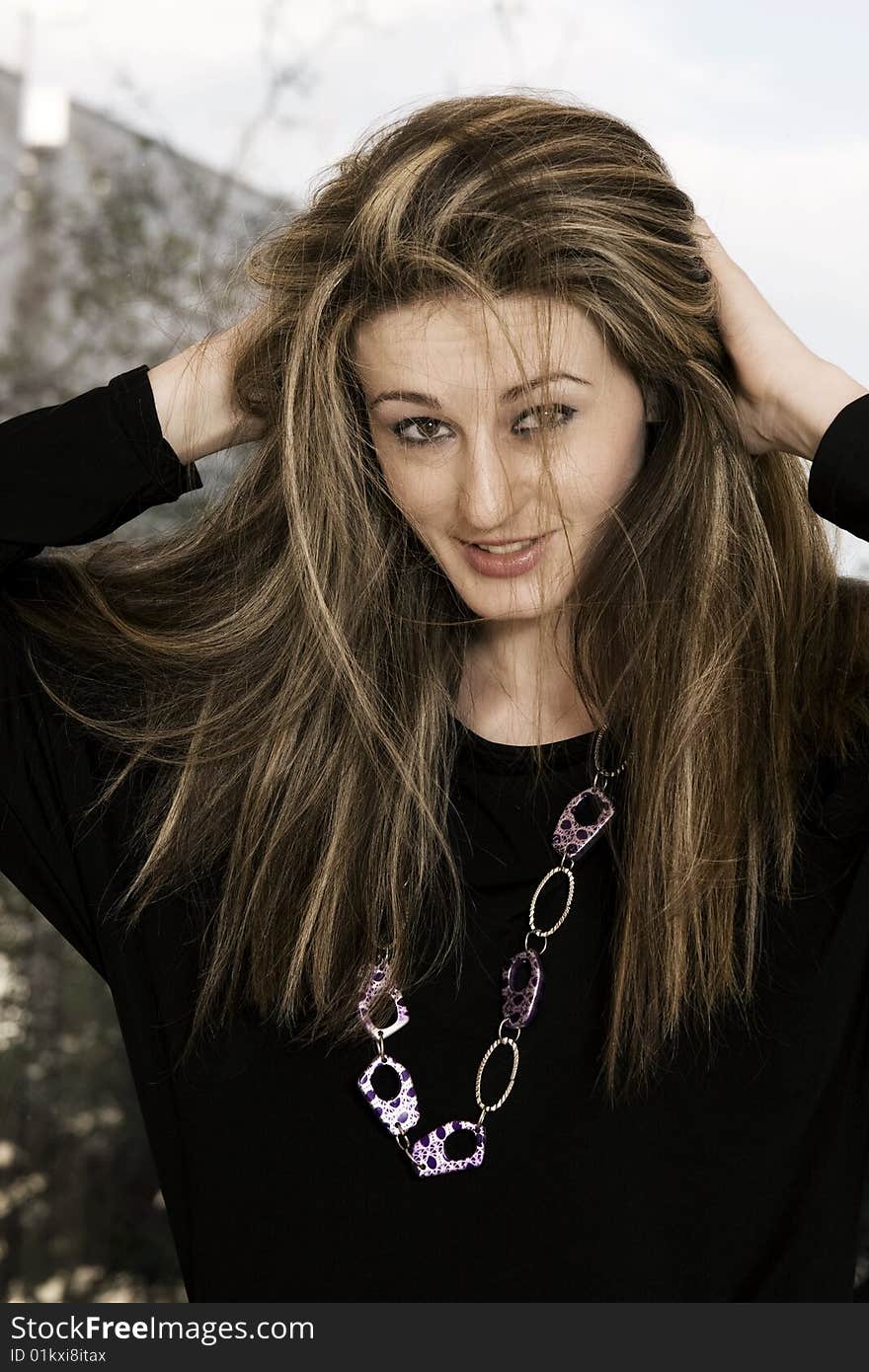 Beautiful young woman smiling and holding her hair. Beautiful young woman smiling and holding her hair