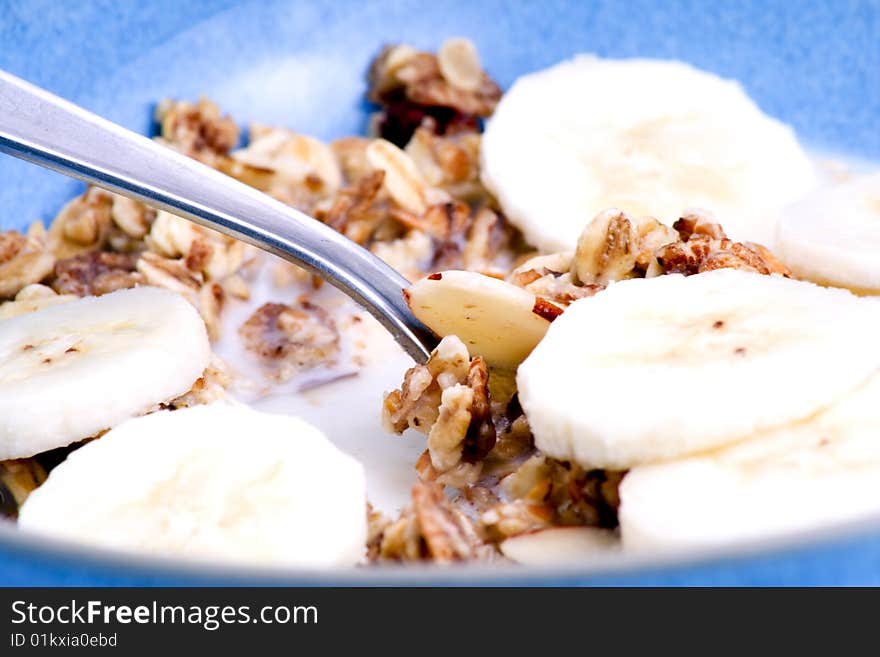 Detail of a bowl of muesli with spoon and banana slices. Detail of a bowl of muesli with spoon and banana slices