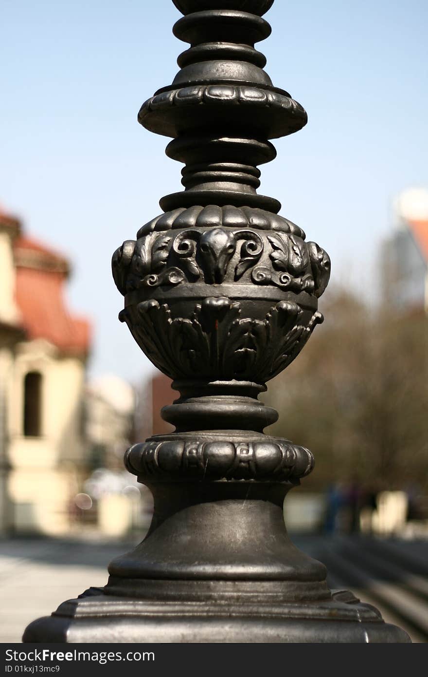 The detail of the old wrougt metal varnished pillar. Prague, Czech republic. The detail of the old wrougt metal varnished pillar. Prague, Czech republic.