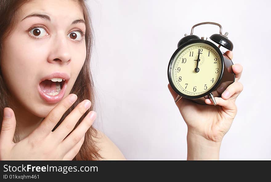 Portrait of the scared girl holding an alarm clock in a hand. Portrait of the scared girl holding an alarm clock in a hand.