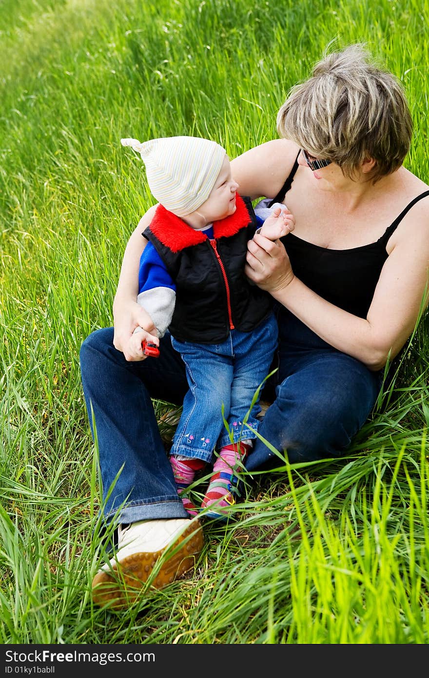 Small girl on the grass with grandmother. Small girl on the grass with grandmother