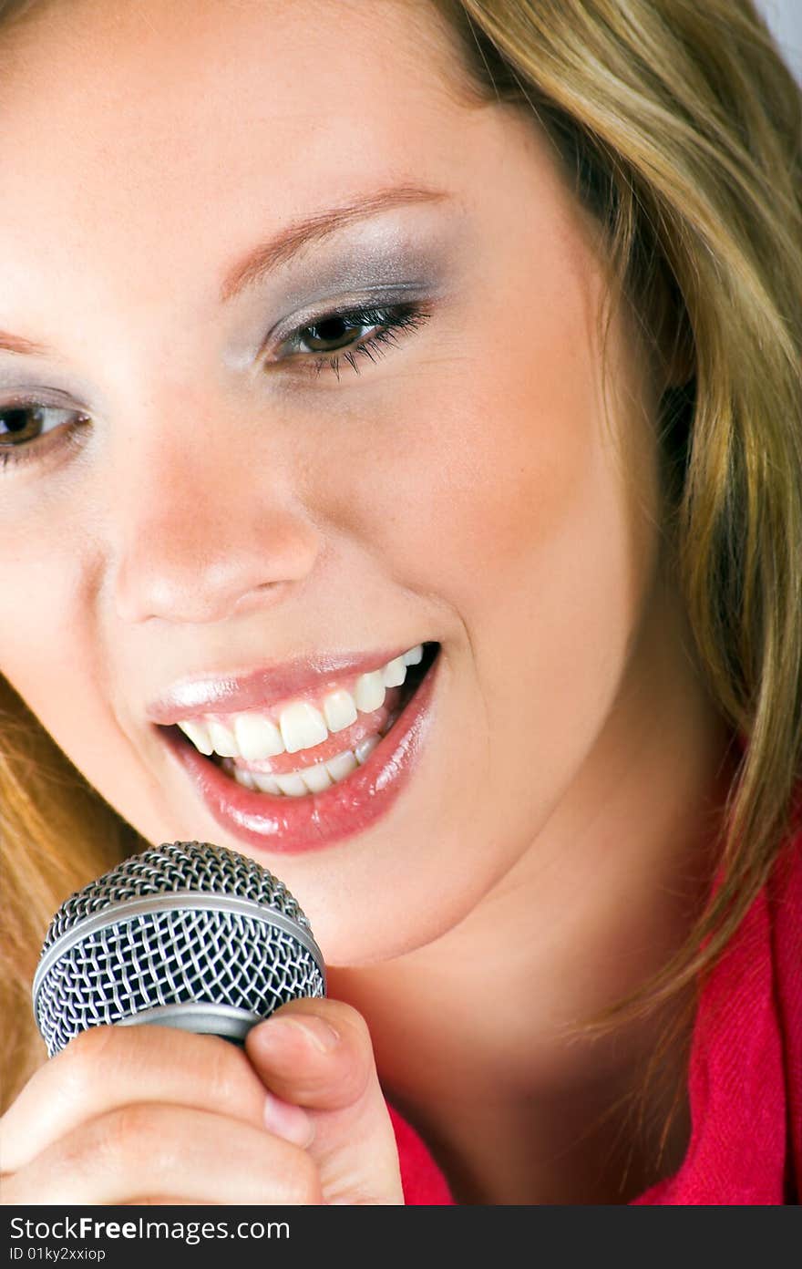 Portrait of a happy singing woman with a microphone. Portrait of a happy singing woman with a microphone