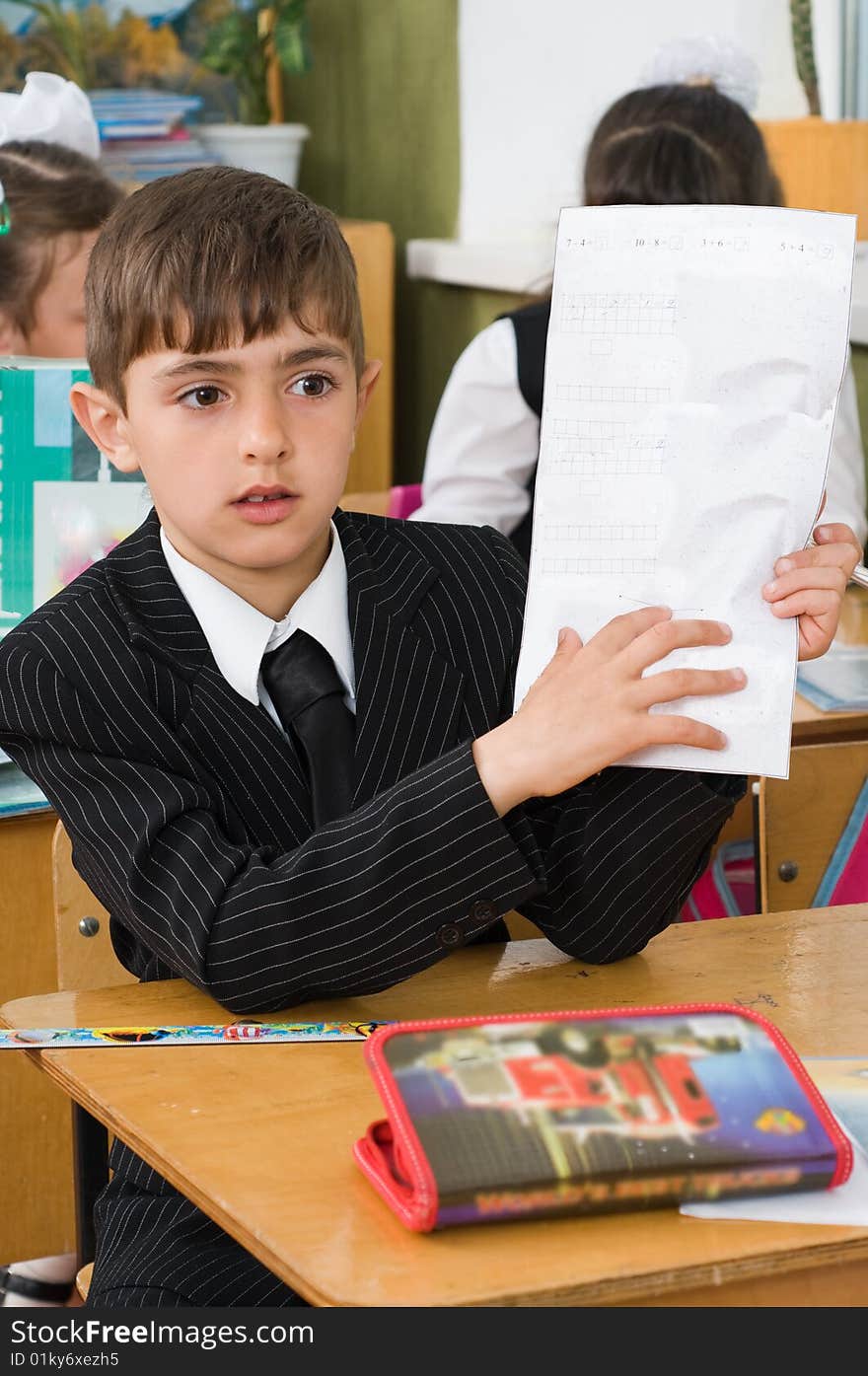 The first-grader holds a sheet of paper.