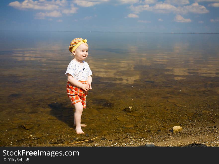 Small girl over the blue sky near the dirty river. Small girl over the blue sky near the dirty river