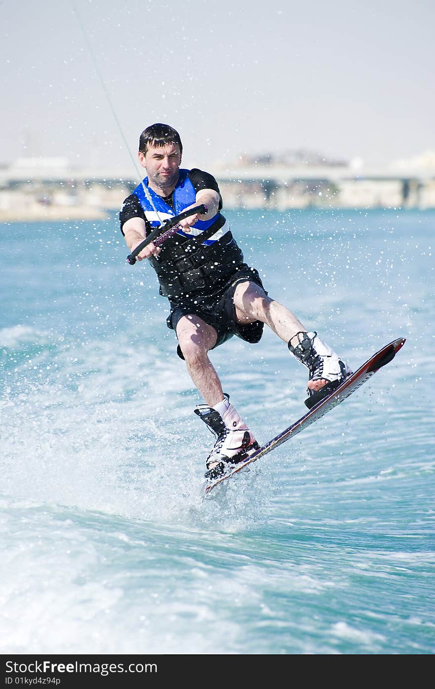 A wakeboarder enjoying the action of riding the wake of the boat. A wakeboarder enjoying the action of riding the wake of the boat.