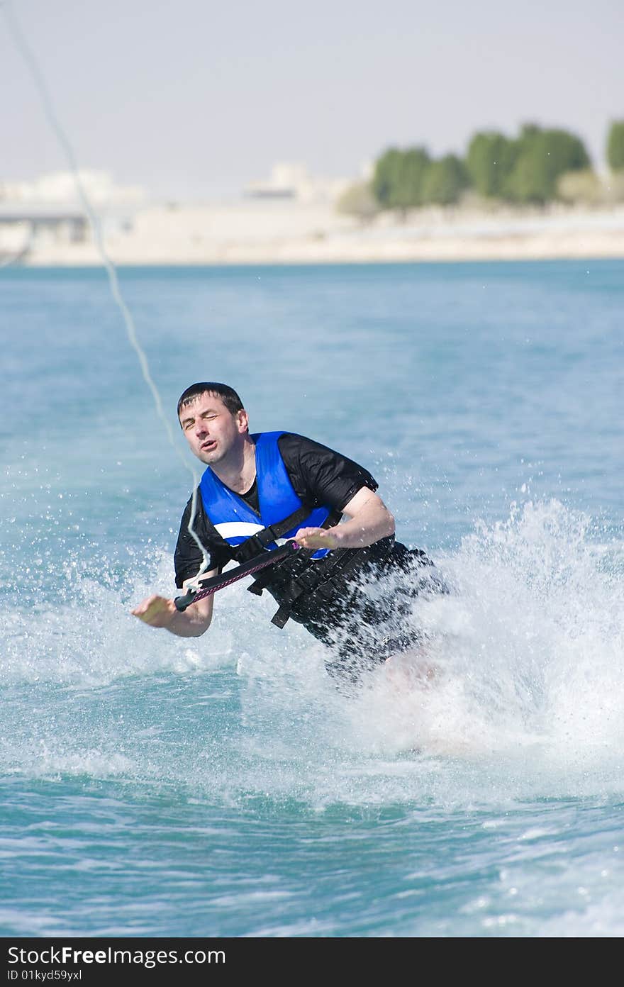 A wakeboarder enjoying the action of riding the wake of the boat, taking a fall. A wakeboarder enjoying the action of riding the wake of the boat, taking a fall.