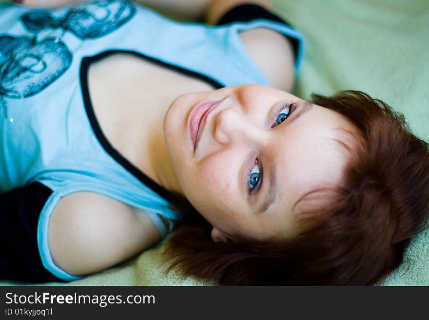 The girl looks expressive blue eyes, a blue T-shirt and looks forward. The girl looks expressive blue eyes, a blue T-shirt and looks forward