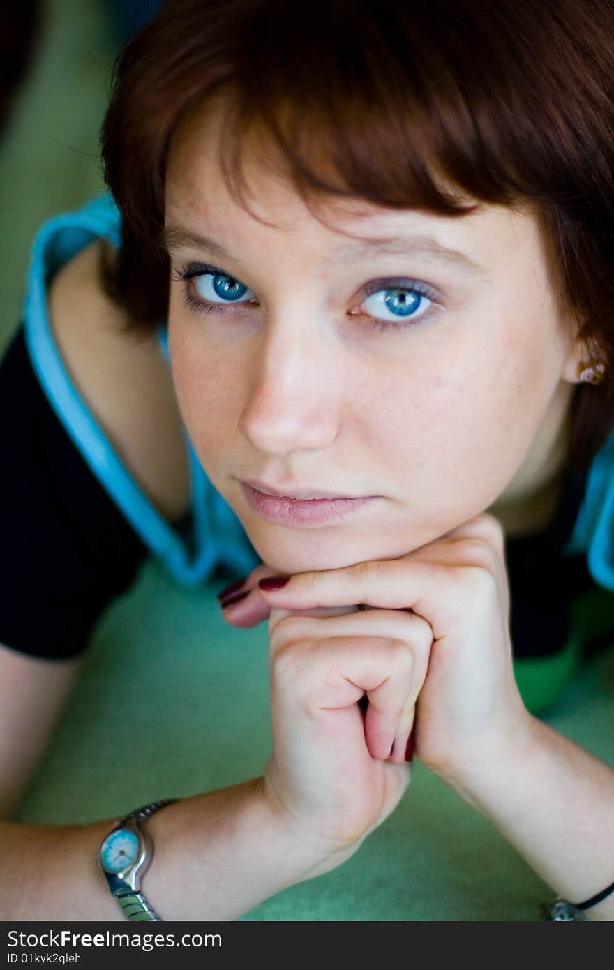 The girl looks expressive blue eyes, a blue T-shirt and looks forward. The girl looks expressive blue eyes, a blue T-shirt and looks forward