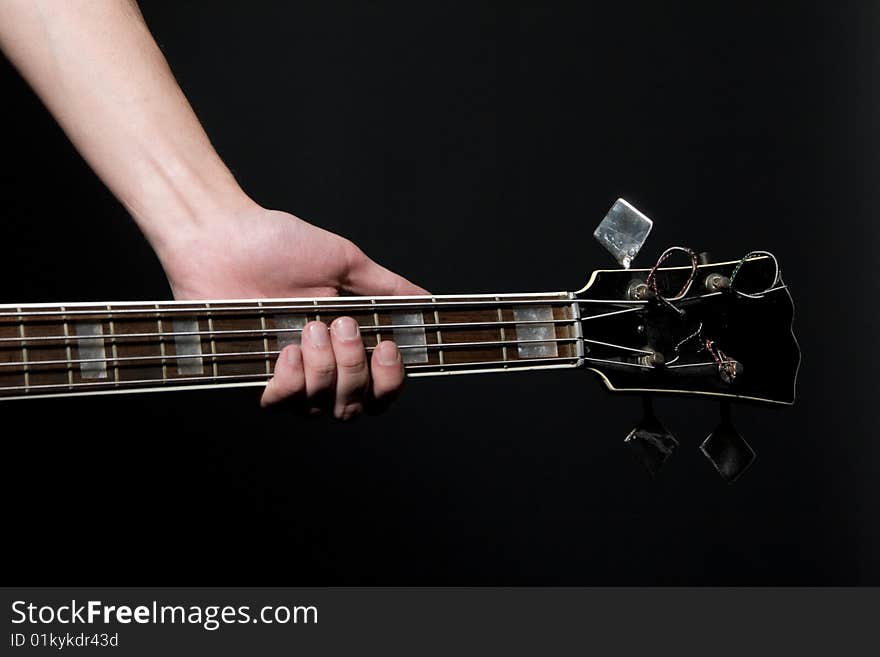 Musician with vintage bass guitar on black background.