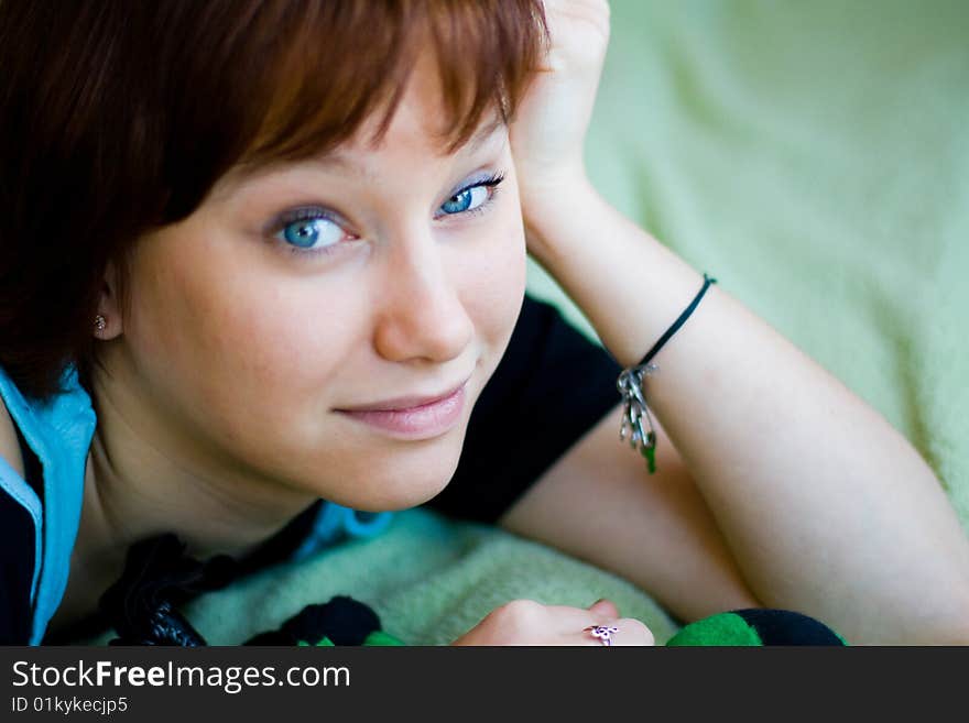 The girl looks expressive blue eyes, a blue T-shirt and looks forward. The girl looks expressive blue eyes, a blue T-shirt and looks forward