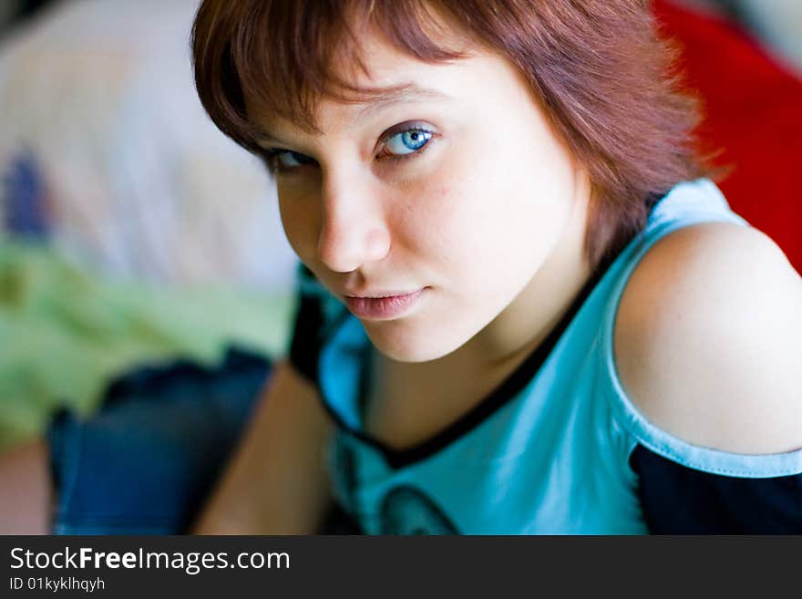 The girl looks expressive blue eyes, a blue T-shirt and looks forward. The girl looks expressive blue eyes, a blue T-shirt and looks forward