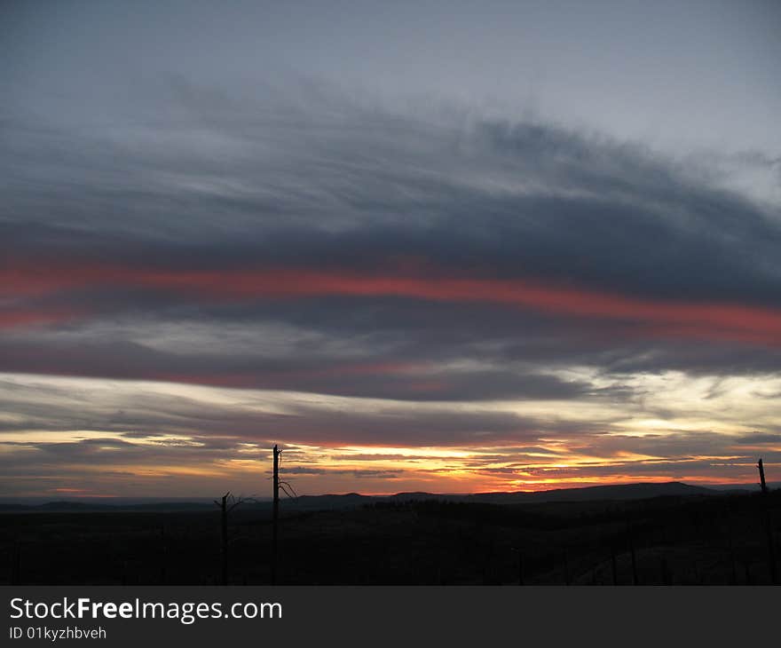 A red stripe in the clouds above the Prairie seen from the Black Hills in South Dakota. A red stripe in the clouds above the Prairie seen from the Black Hills in South Dakota