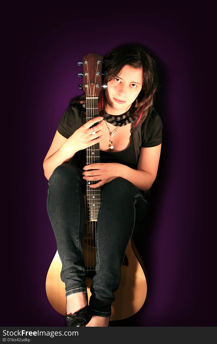 Beautiful Young Woman Holding an Acoustic Guitar with Purple Background. Beautiful Young Woman Holding an Acoustic Guitar with Purple Background