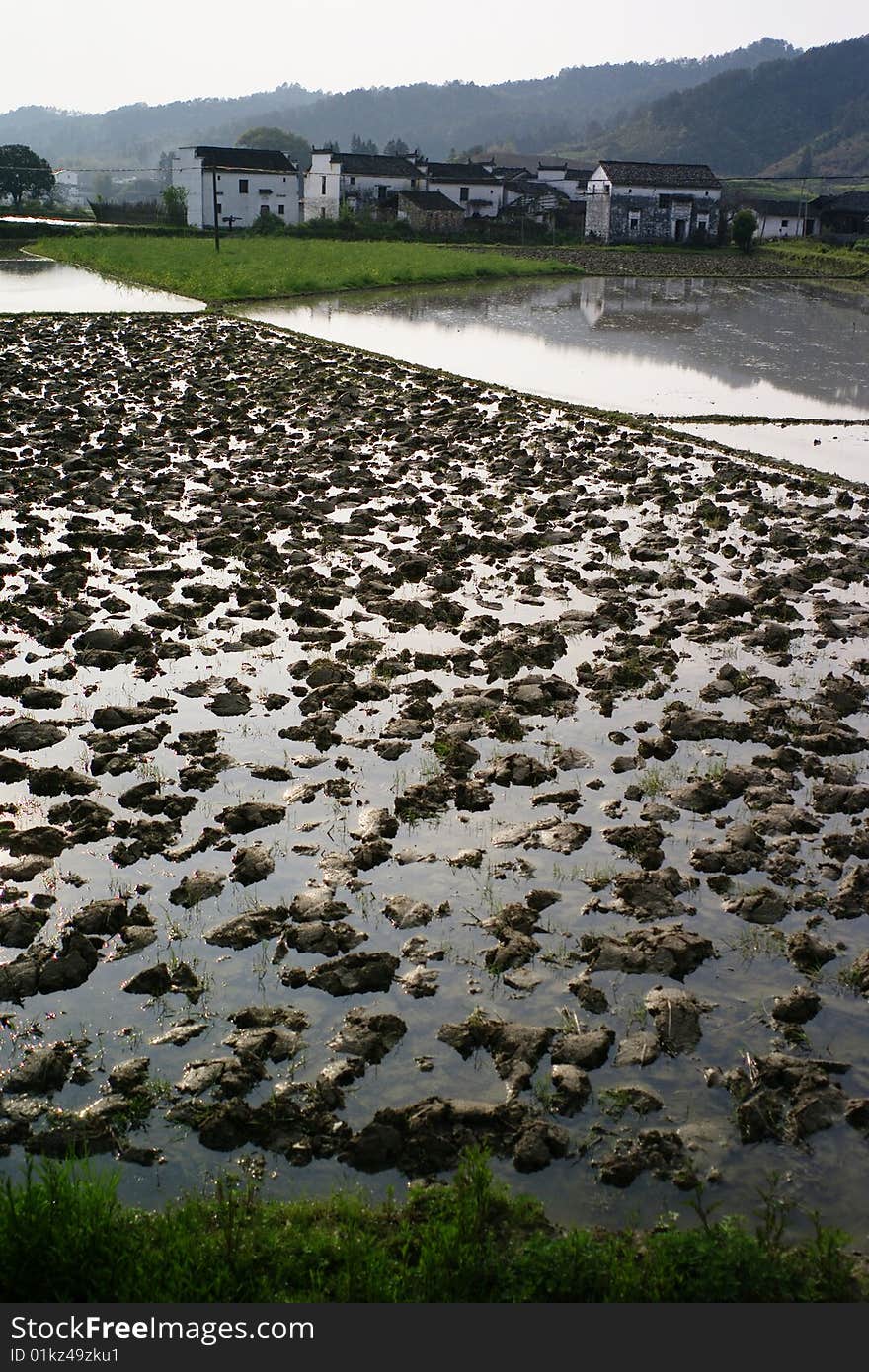 Plowed ground and buildings in farmland. Plowed ground and buildings in farmland.