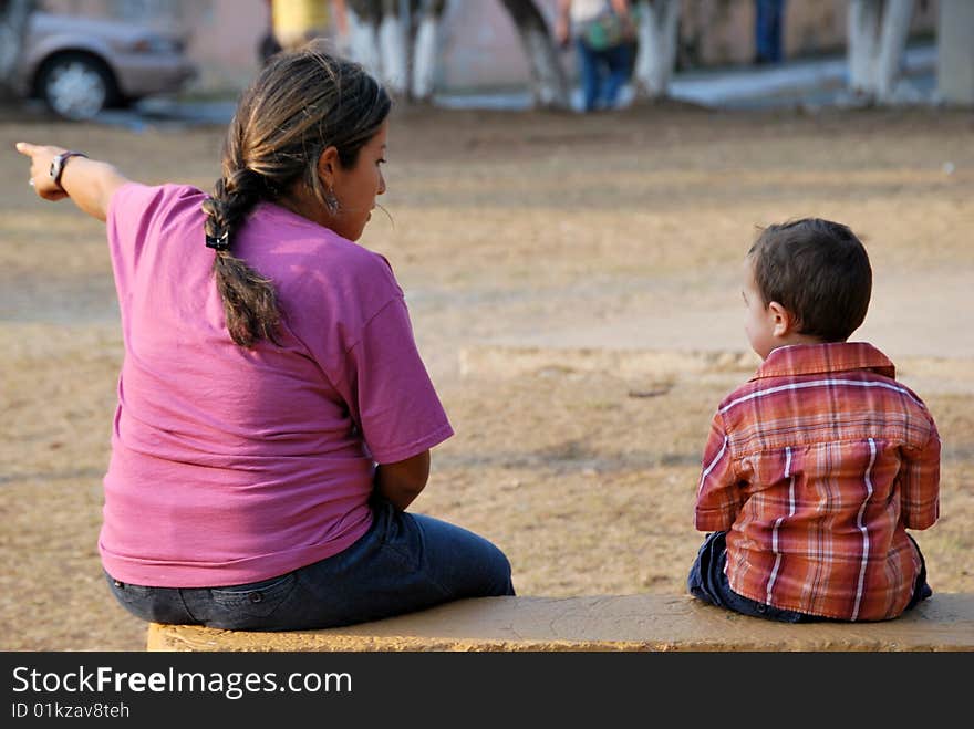 Beautiful Hispanic mother and child enjoying each other.  Sitting together on a bench. Beautiful Hispanic mother and child enjoying each other.  Sitting together on a bench.