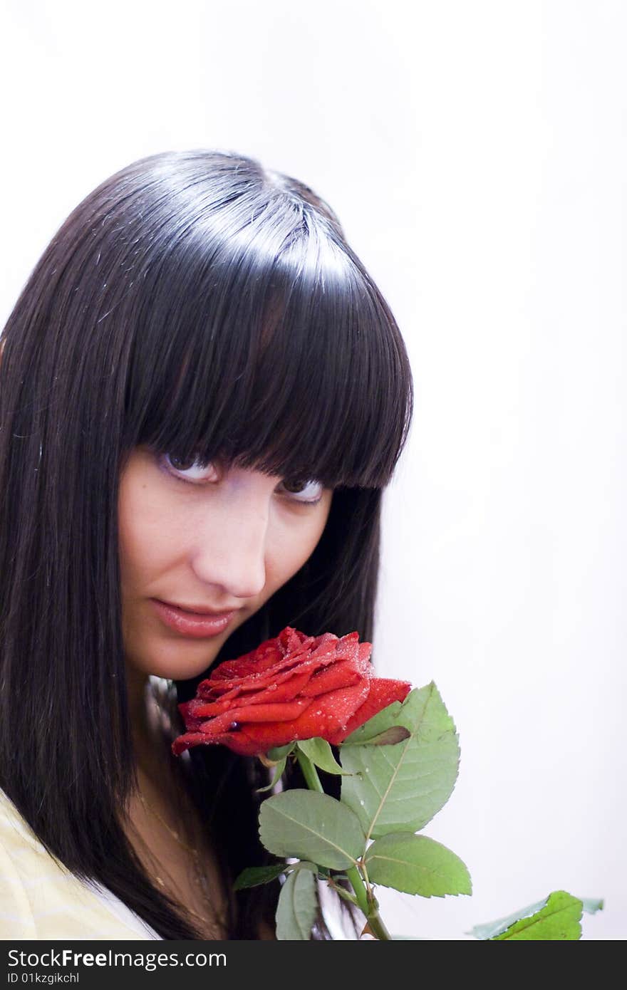 Girl sniffing beautiful flower - red rose. Girl sniffing beautiful flower - red rose