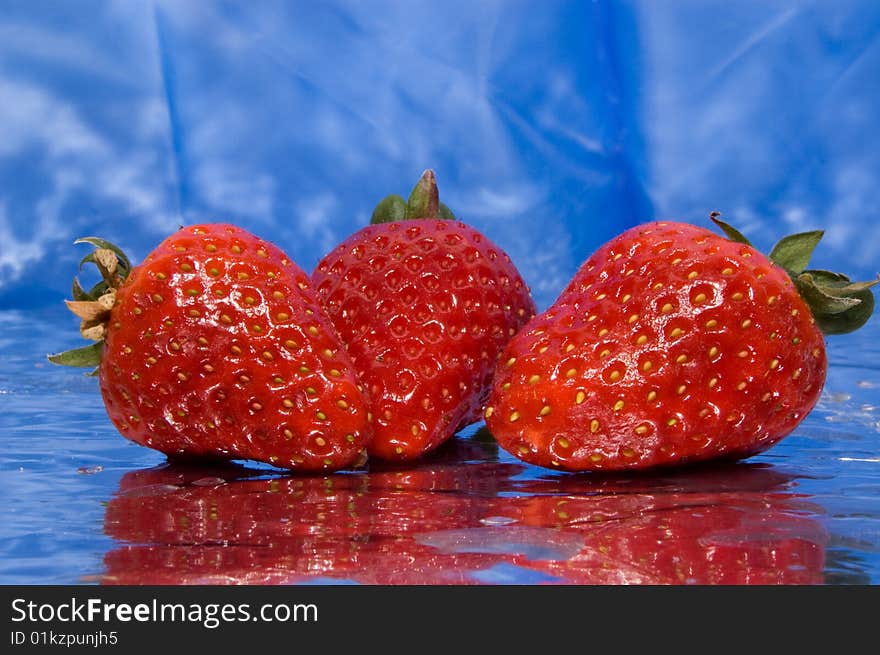 Wet strawberries on a blue background