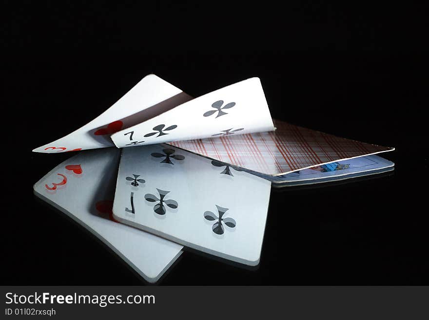 Two opened cards and one closed playing card on dark background. Two opened cards and one closed playing card on dark background