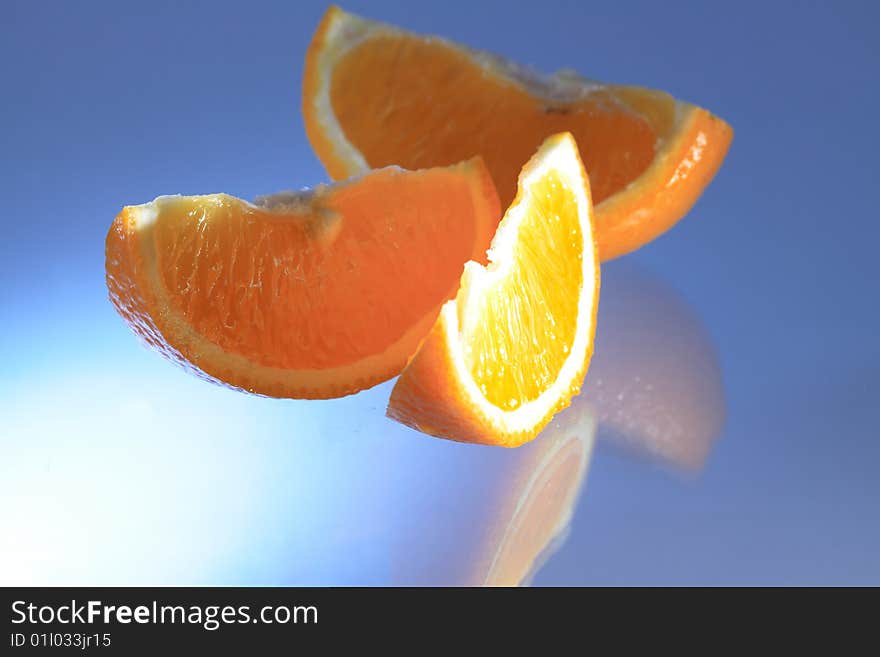 Sliced orange with reverberation on blue background