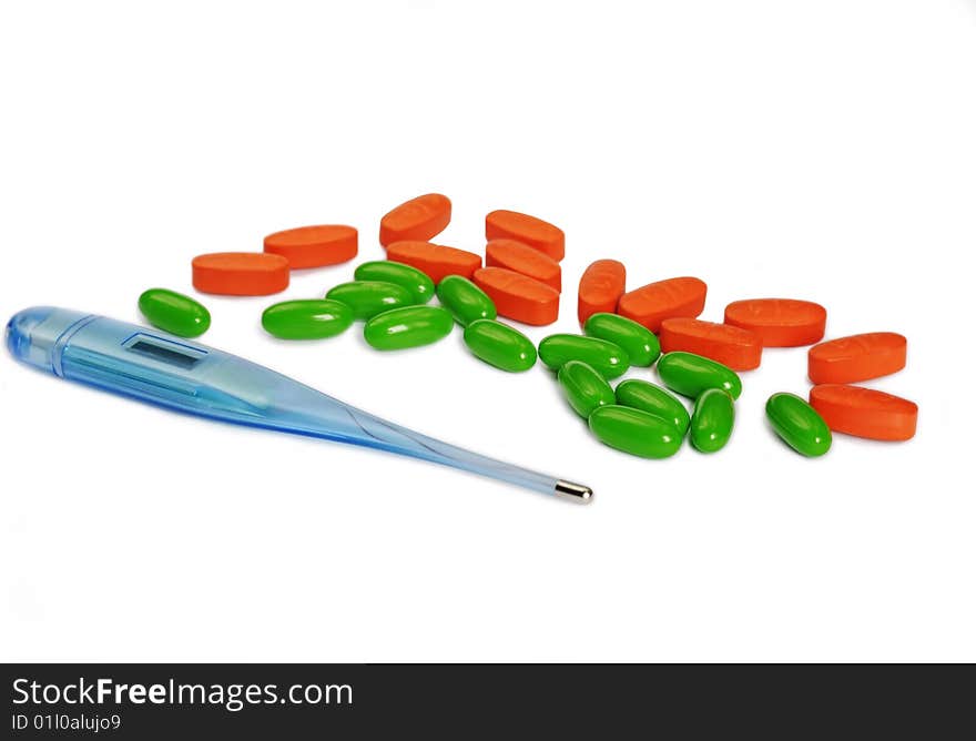 Digital thermometer and group of colorfull green and orange pills and capsules. Digital thermometer and group of colorfull green and orange pills and capsules