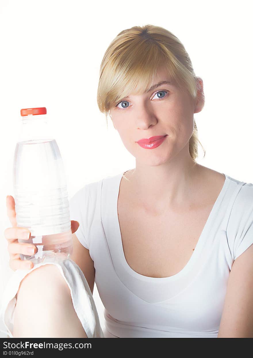 The girl of a sports kind with a bottle of water in a hand. The girl of a sports kind with a bottle of water in a hand