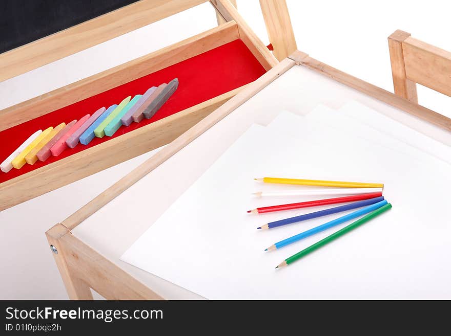 Details of blackboard with chalks and desk with pencils in kindergarten. Details of blackboard with chalks and desk with pencils in kindergarten