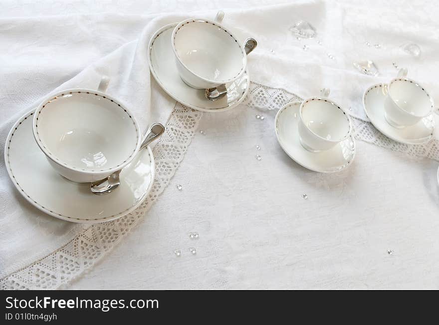 Four teacups on a table with tablecloth