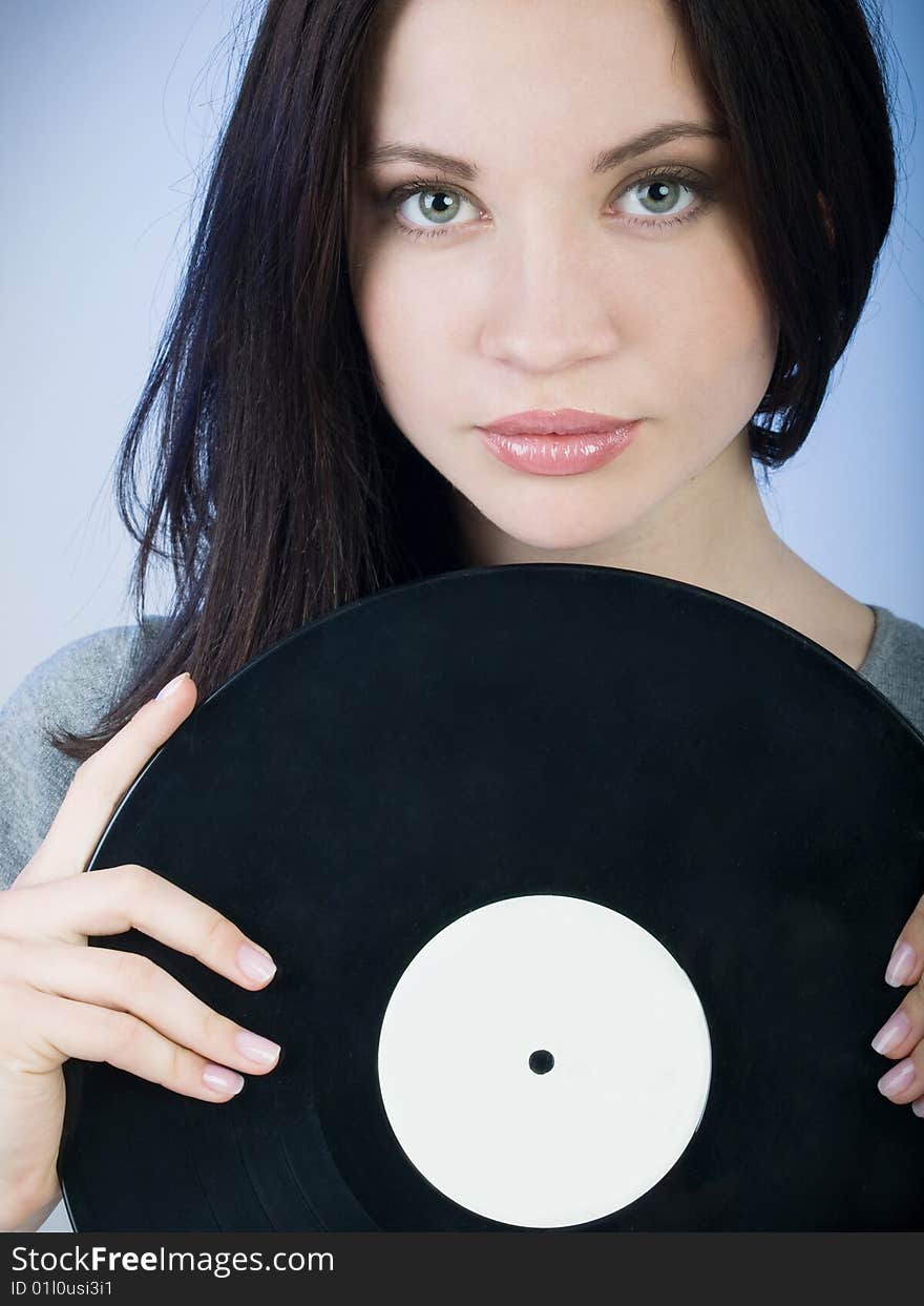 Beautiful girl holding a vinyl record in front of her. Beautiful girl holding a vinyl record in front of her