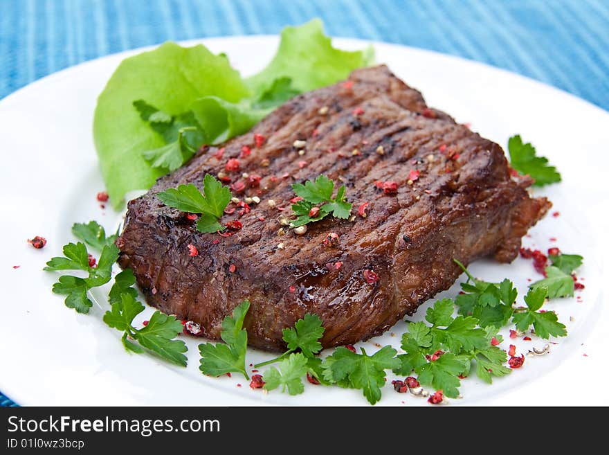 Roast big steak  on green dish close up