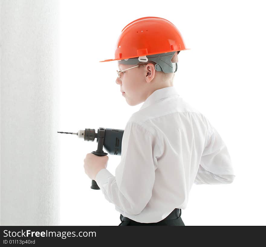 Teenager in protective helmet and spectacles drill the wall. Teenager in protective helmet and spectacles drill the wall