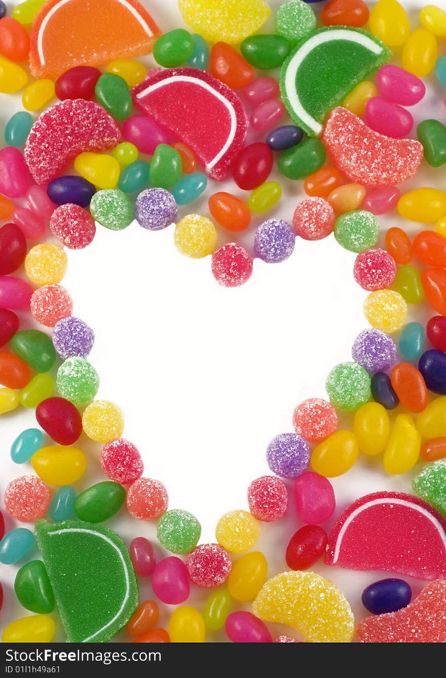 A colorful background of assorted gummy candies, with a heart shape in the middle with white copy space. A colorful background of assorted gummy candies, with a heart shape in the middle with white copy space
