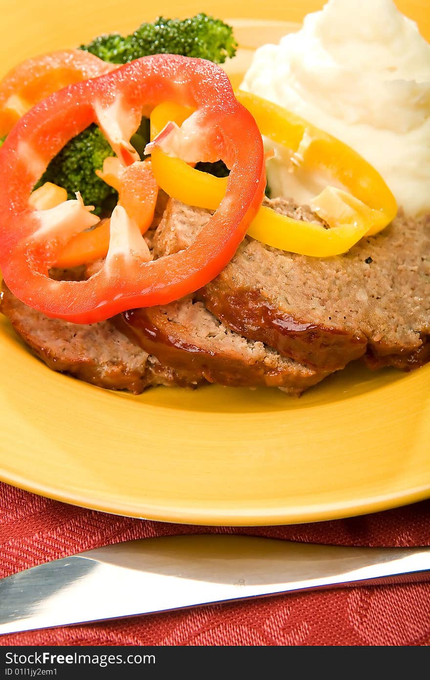 Meatloaf with mashed potatoes and broccoli garnished with pepper rings and glaze. Meatloaf with mashed potatoes and broccoli garnished with pepper rings and glaze