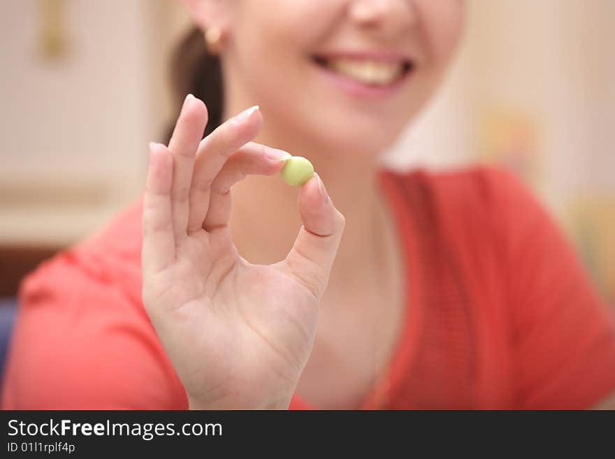 A photo of young girl with green vitamin. A photo of young girl with green vitamin