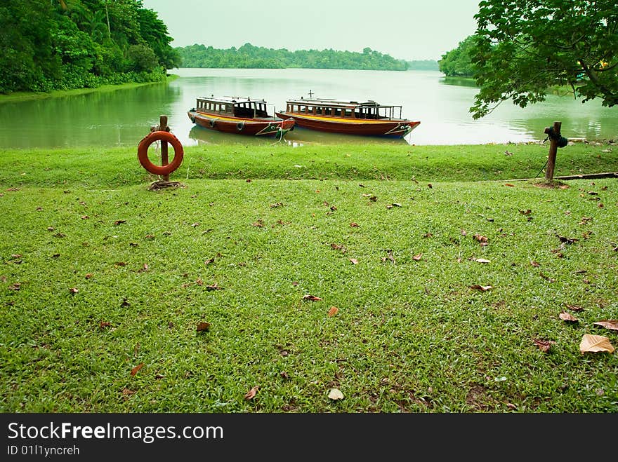 Lakeside with boats parking in green background. Lakeside with boats parking in green background