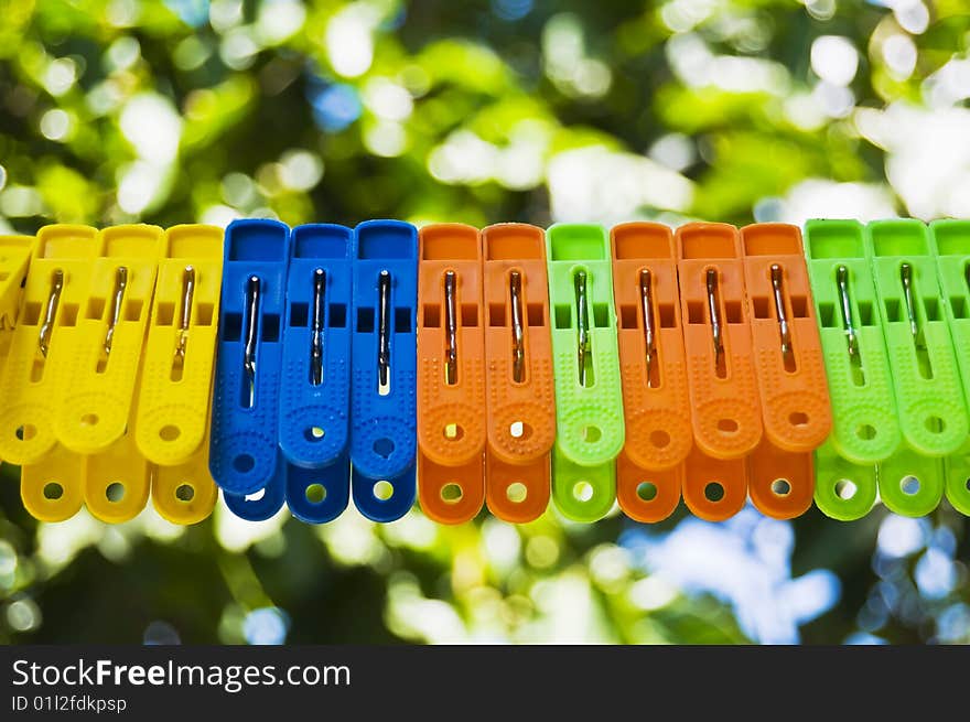 Clothespins on clothesline against green background