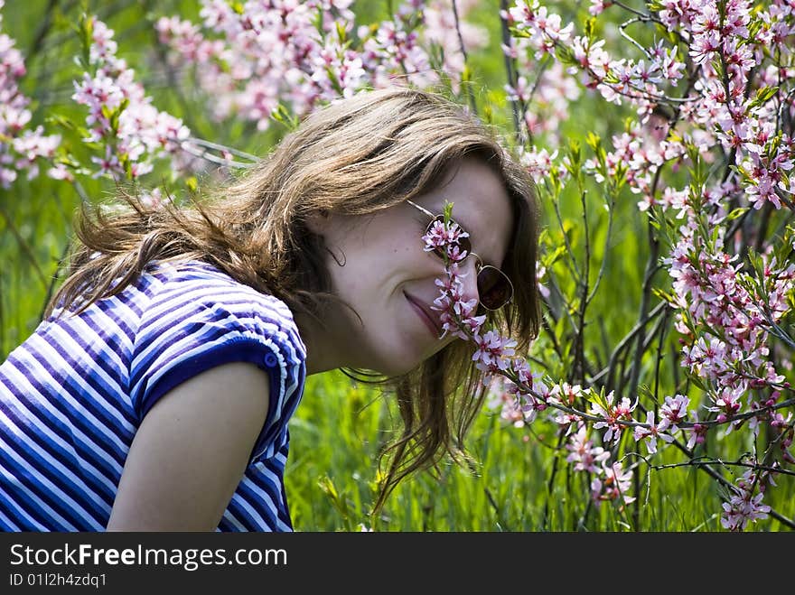 Young beautiful girl smelling flowers;beautiful spring day. Young beautiful girl smelling flowers;beautiful spring day