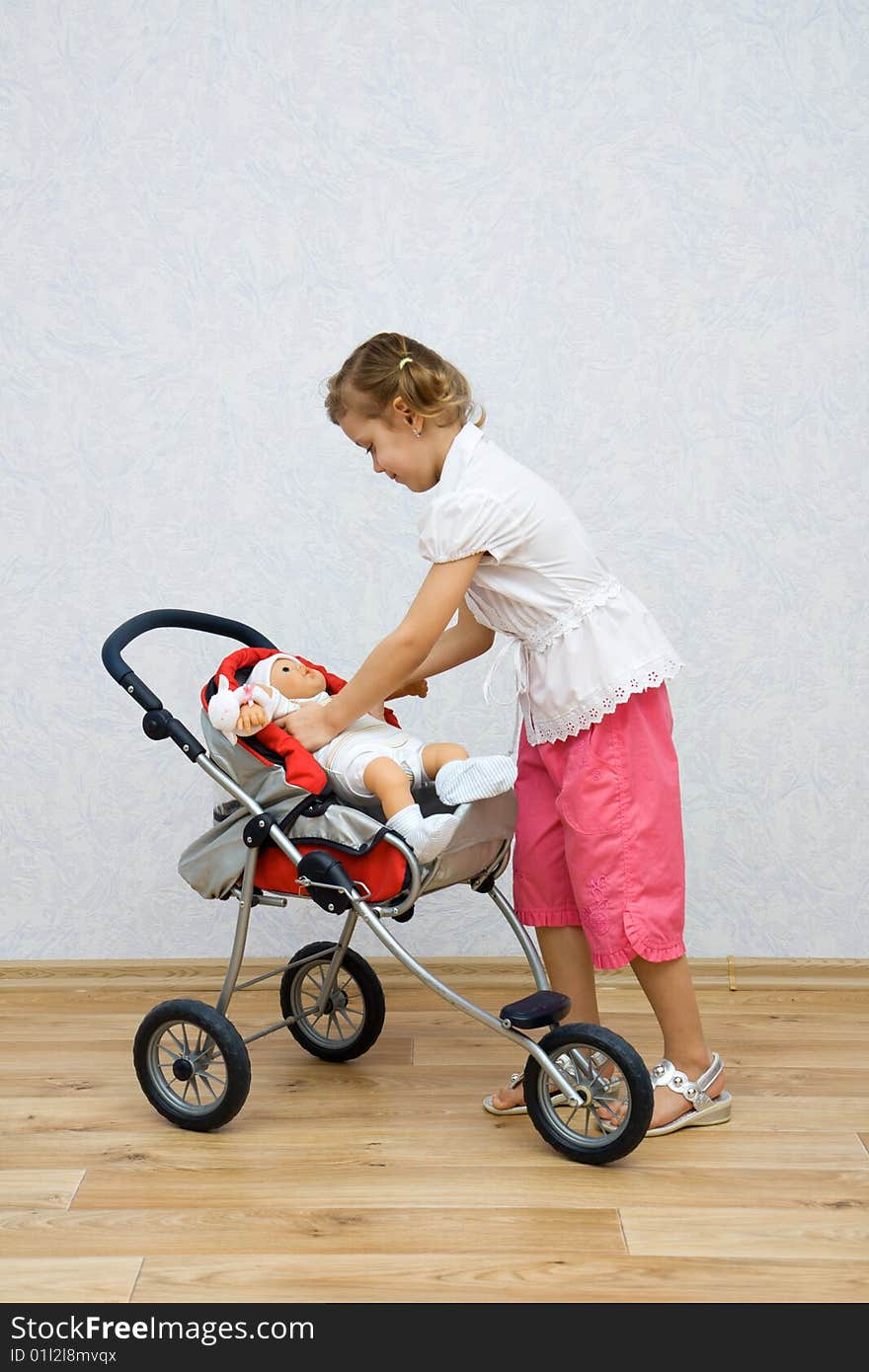 Little pretty caucasian girl playing with doll. Little pretty caucasian girl playing with doll